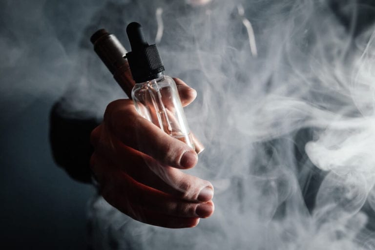 bottle of e-juice in the hand of a vaper