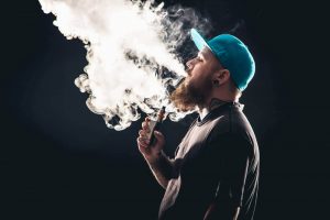 緑のキャップvaping画像でクラウド追いかけ男